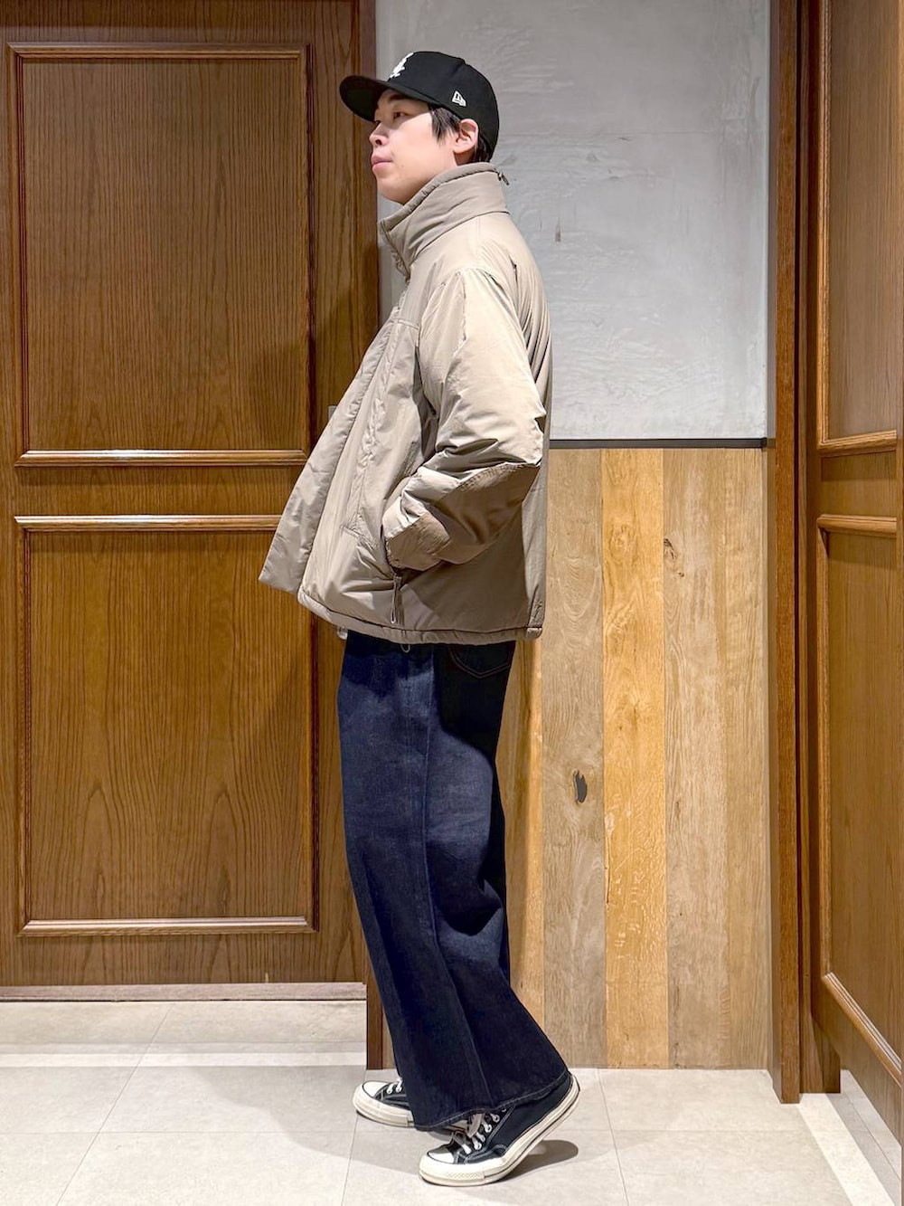 ブルー系のデニムパンツ、ブラウン系のダウンジャケット/コート、ブラウン系のニット/セーターを着用したメンズの冬コーディネートの5枚目の写真