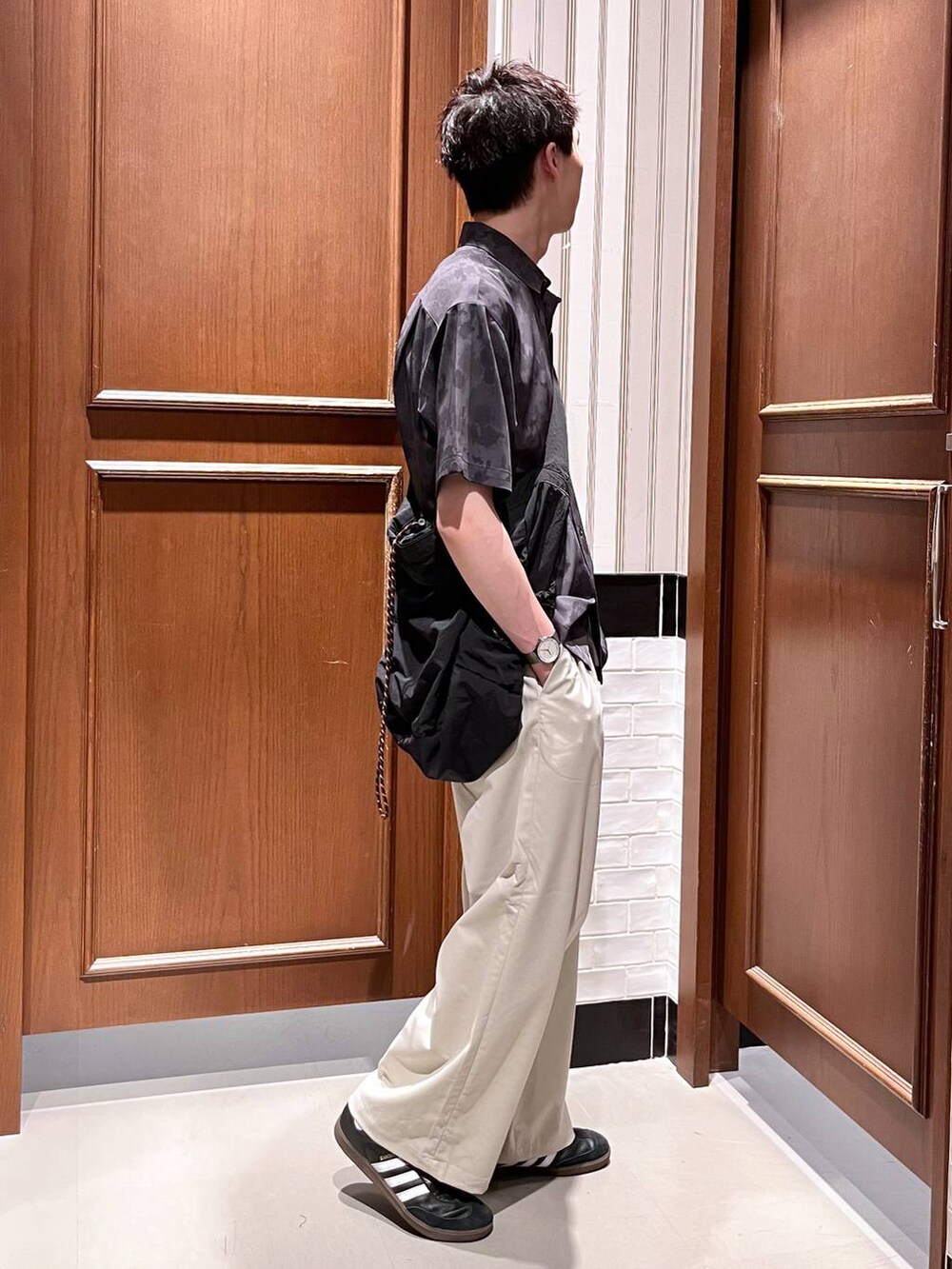 ホワイト系のスラックス、ブラック系のシャツ/ブラウス、ブラック系のショルダーバッグを着用したメンズの夏コーディネートの6枚目の写真