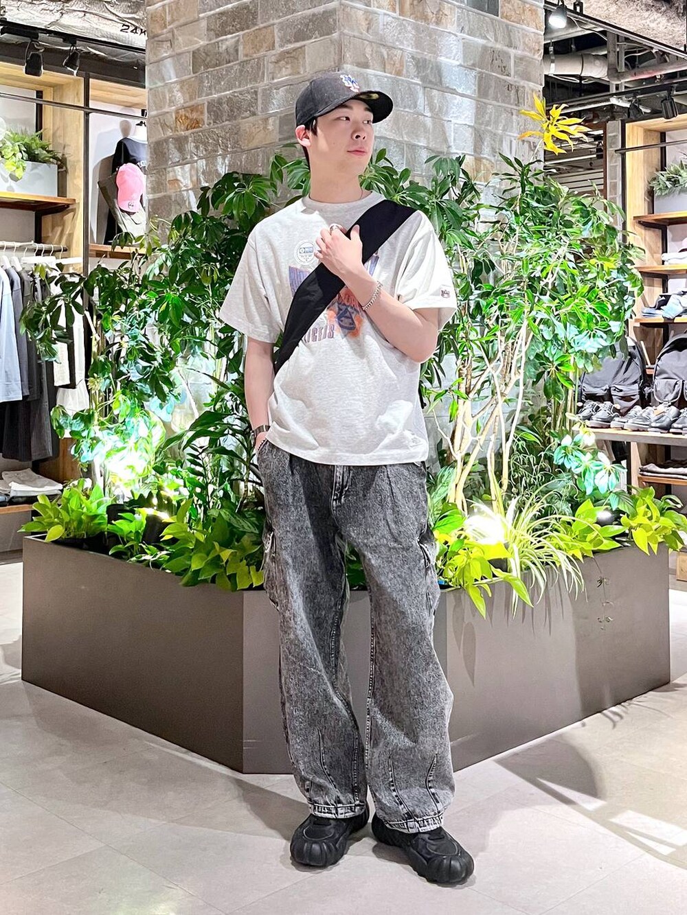 ブラック系のショルダーバッグ、グレー系のデニムパンツ、ホワイト系のTシャツ/カットソーを着用したメンズの春コーディネートの2枚目の写真