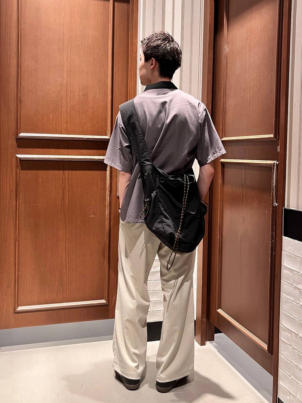 ホワイト系のスラックス、ブラック系のショルダーバッグ、グレー系のシャツ/ブラウスを着用したメンズの夏コーディネートの4枚目の写真