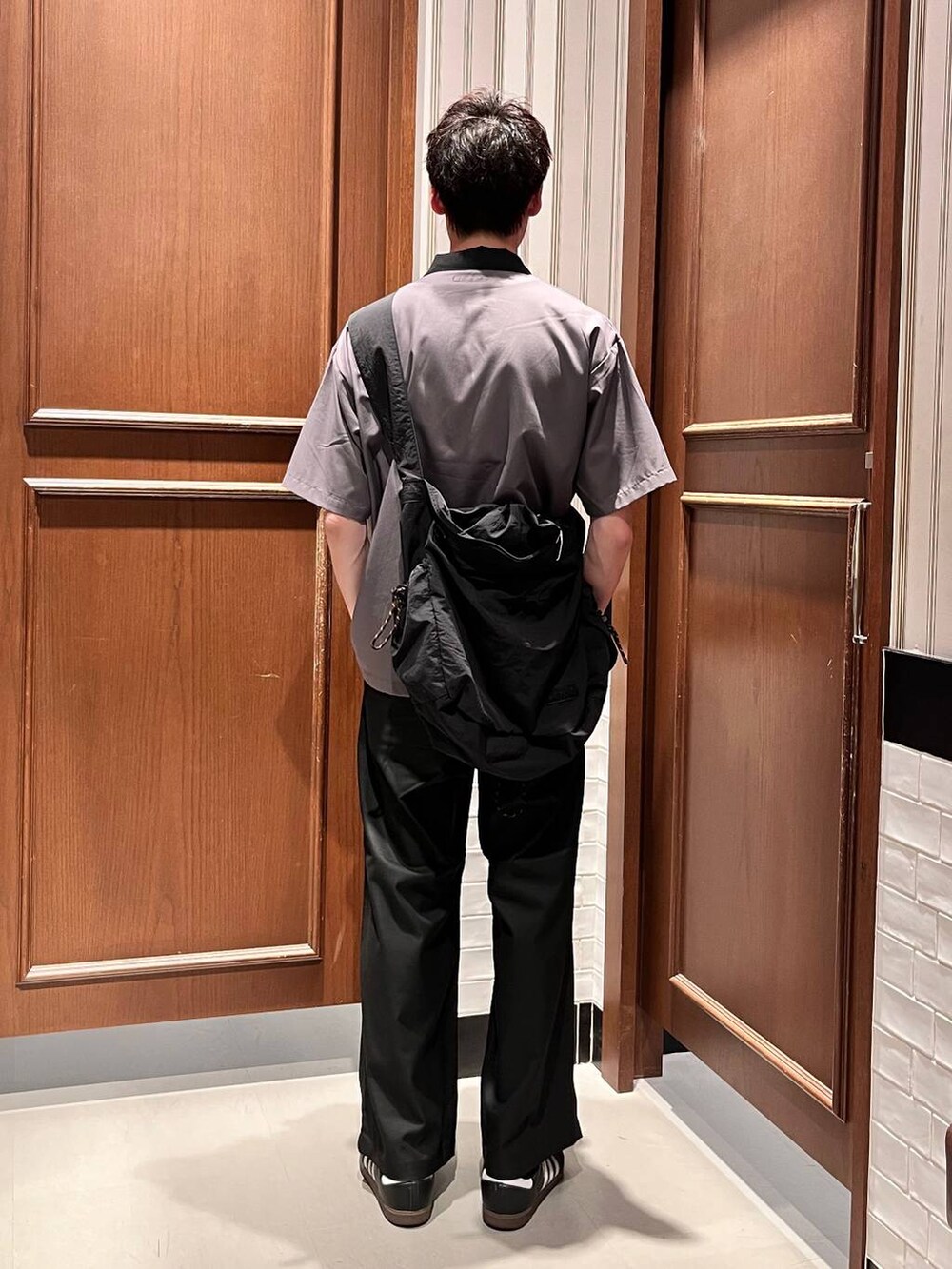 ブラック系のスラックス、ブラック系のショルダーバッグ、グレー系のシャツ/ブラウスを着用したメンズの夏コーディネートの4枚目の写真