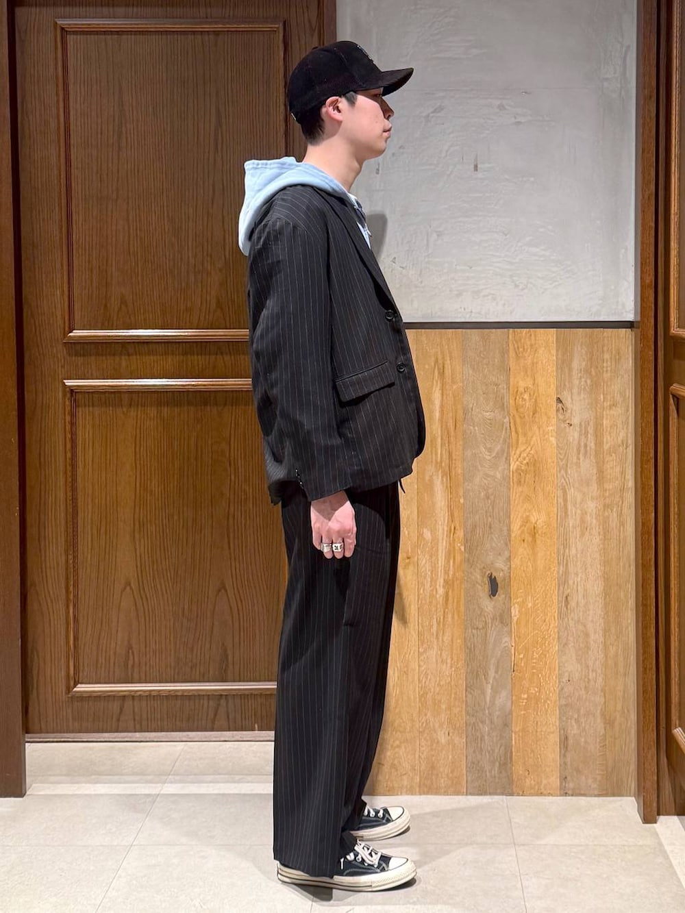 ブラック系のスラックス、ブラック系のテーラードジャケット、ブルー系のパーカーを着用したメンズの冬コーディネートの6枚目の写真