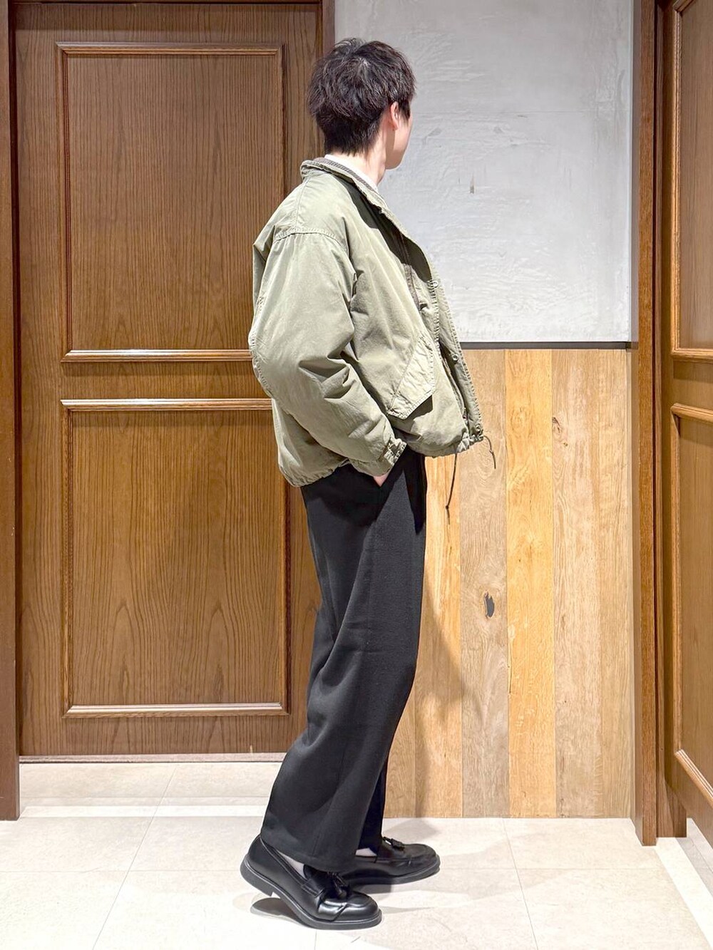 グリーン系のモッズコート、ブラック系のスラックス、ホワイト系のシャツ/ブラウスを着用したメンズの冬コーディネートの6枚目の写真