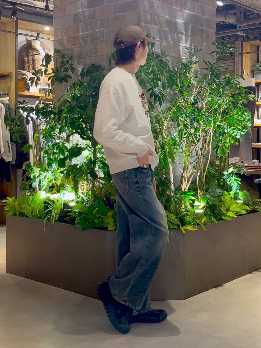 ブルー系のデニムパンツ、ホワイト系のスウェット、ブラウン系のキャップを着用したメンズの冬コーディネートの3枚目の写真