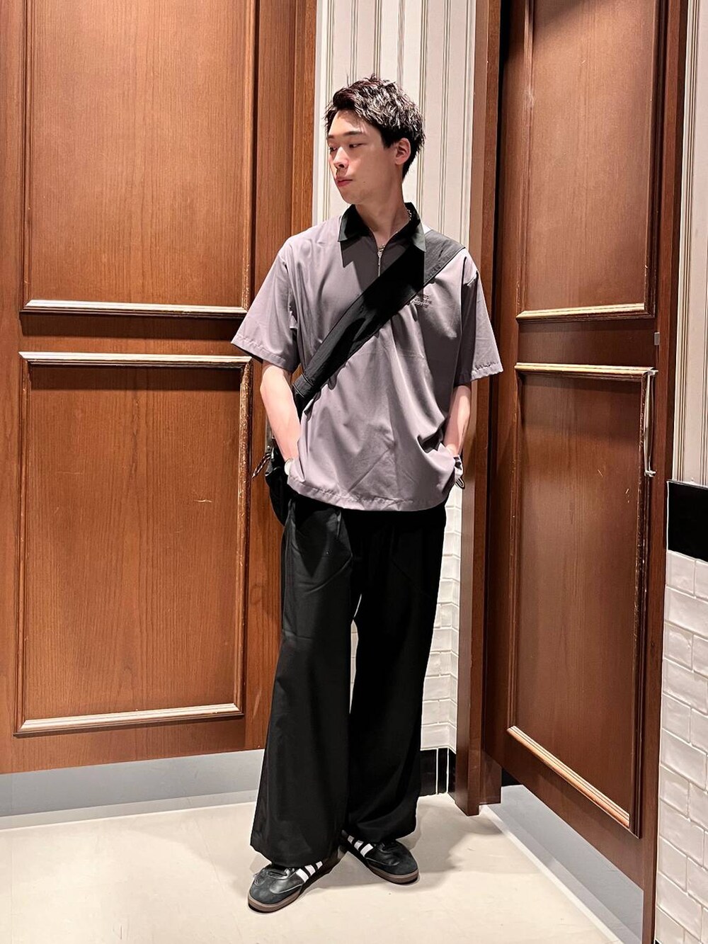 ブラック系のスラックス、ブラック系のショルダーバッグ、グレー系のシャツ/ブラウスを着用したメンズの夏コーディネートの2枚目の写真