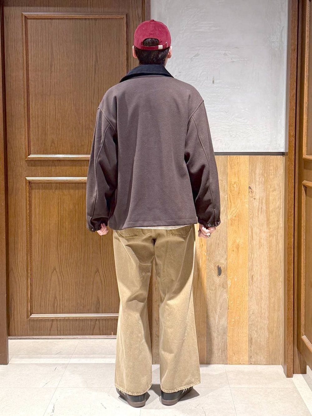 ブラウン系のブルゾン、ホワイト系のニット/セーター、ベージュ系のデニムパンツを着用したメンズの冬コーディネートの6枚目の写真