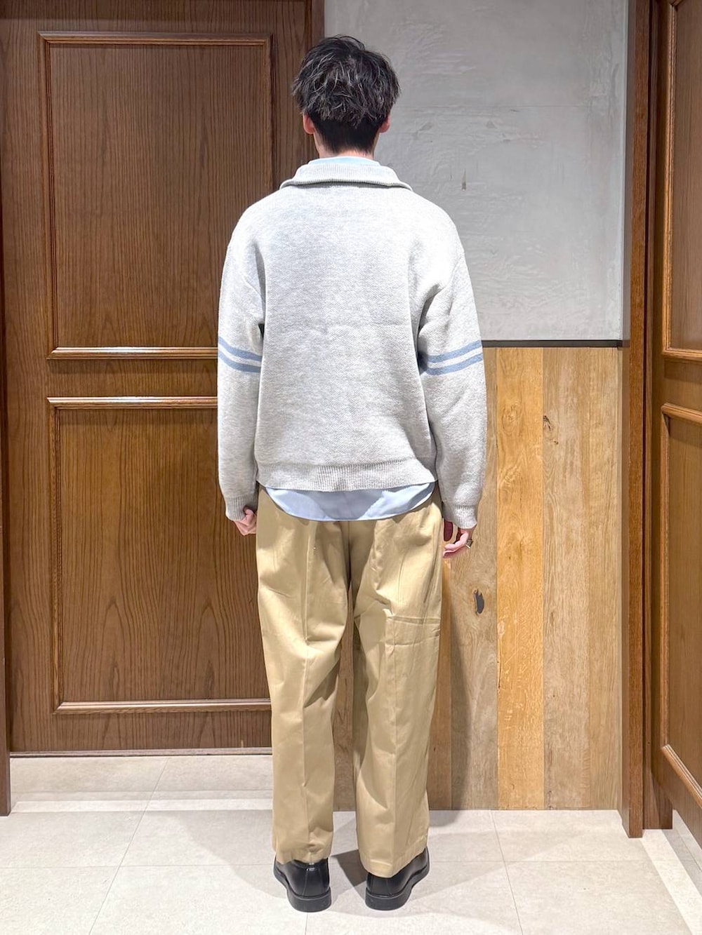 ブルー系のシャツ/ブラウス、ベージュ系のチノパンツ、グレー系のニット/セーターを着用したメンズの冬コーディネートの4枚目の写真