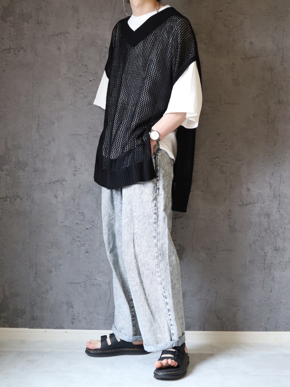 ブラック系のベスト、ホワイト系のTシャツ/カットソー、ブルー系のデニムパンツを着用したメンズの春コーディネートの3枚目の写真