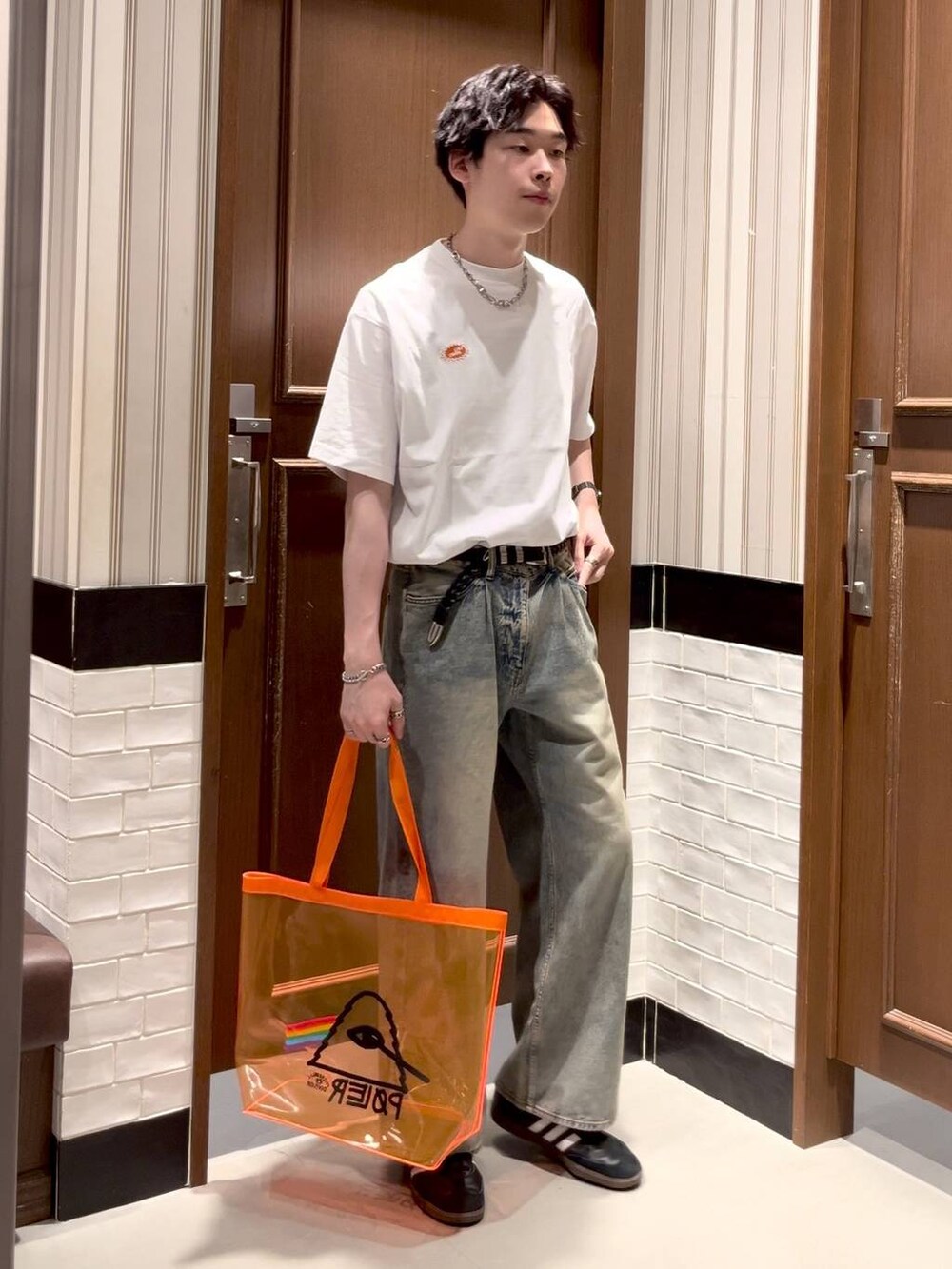 オレンジ系のショルダーバッグ、ブルー系のデニムパンツ、ホワイト系のTシャツ/カットソーを着用したメンズの夏コーディネートの3枚目の写真