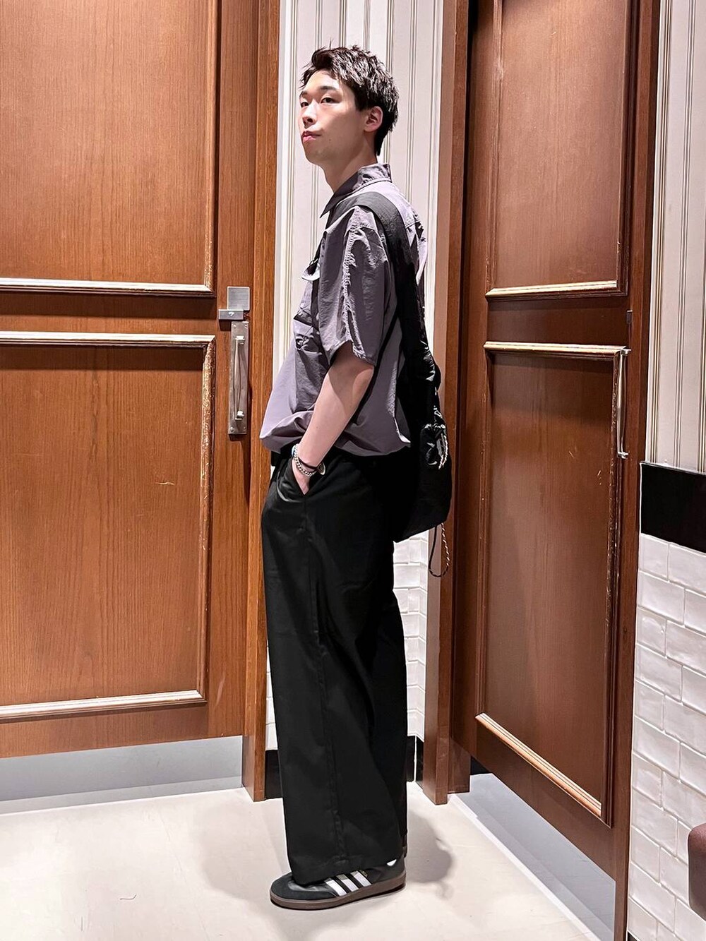 ブラック系のスラックス、ブラック系のショルダーバッグを着用したメンズの夏コーディネートの5枚目の写真