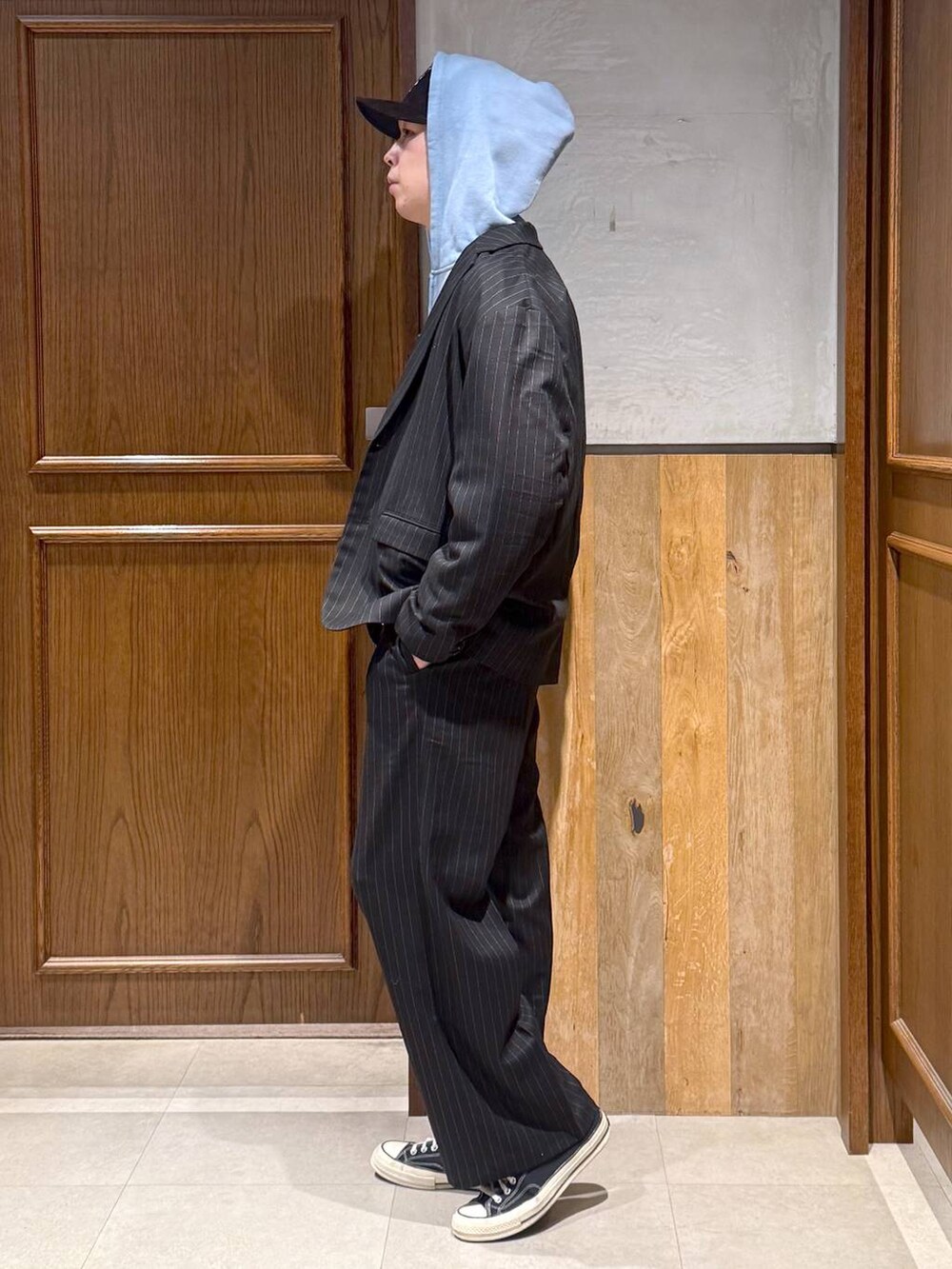 ブラック系のスラックス、ブラック系のテーラードジャケット、ブルー系のパーカーを着用したメンズの冬コーディネートの8枚目の写真