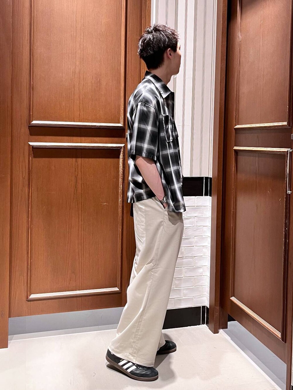 ホワイト系のスラックス、ブラック系のショルダーバッグ、ブラック系のシャツ/ブラウスを着用したメンズの夏コーディネートの5枚目の写真