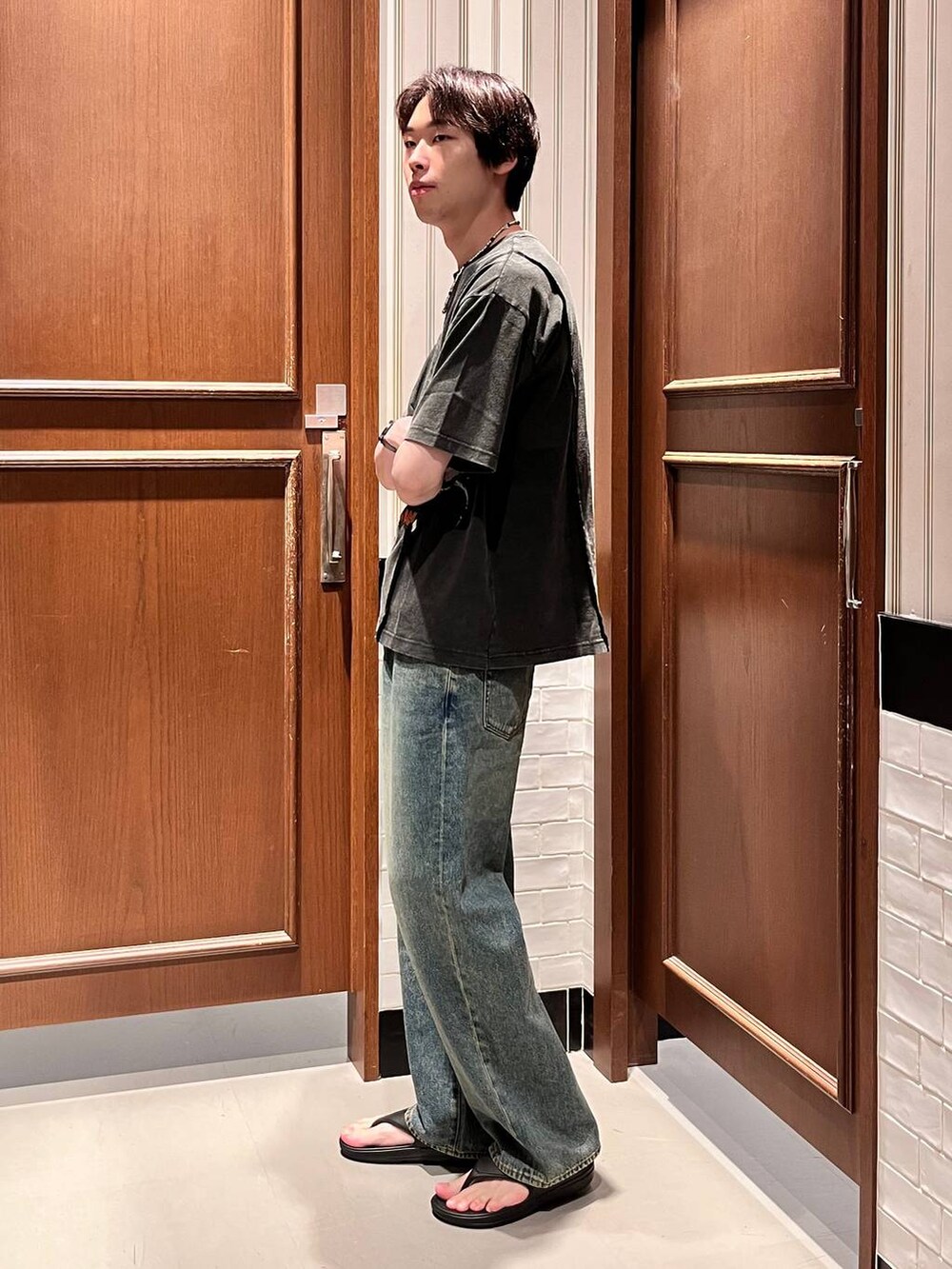 ブラック系のサンダル、ブルー系のデニムパンツ、グレー系のTシャツ/カットソーを着用したメンズの夏コーディネートの4枚目の写真