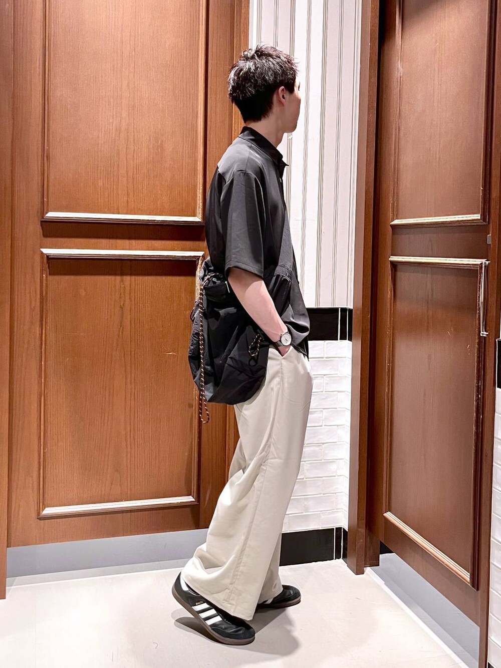 ホワイト系のスラックス、ブラック系のシャツ/ブラウス、ブラック系のショルダーバッグを着用したメンズの夏コーディネートの4枚目の写真