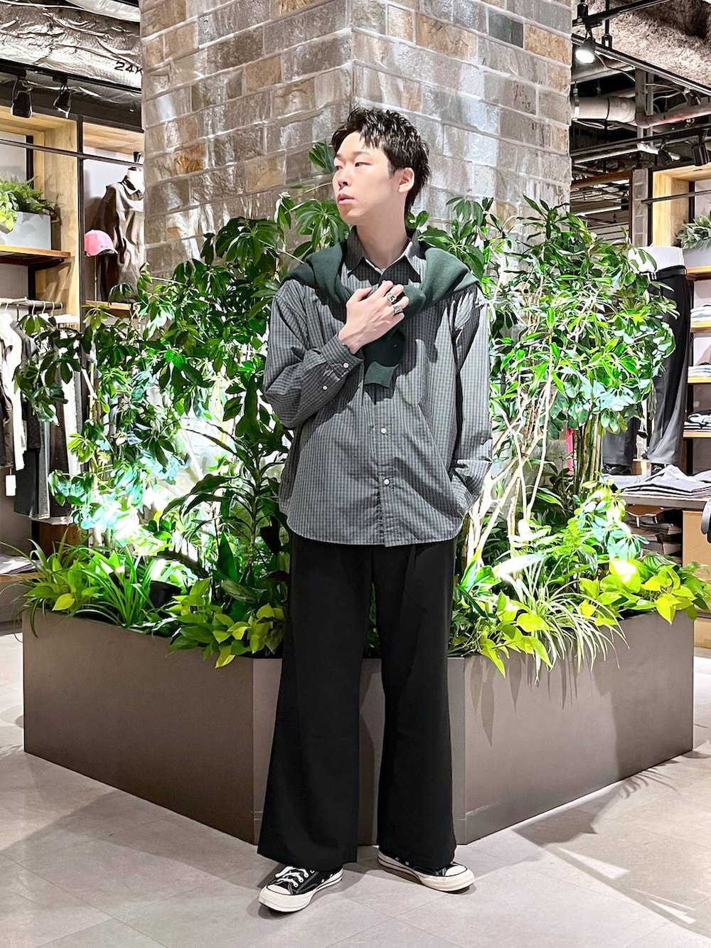 ブラック系のスラックス、ブルー系のシャツ/ブラウス、グリーン系のカーディガン/ボレロを着用したメンズの春コーディネートの2枚目の写真