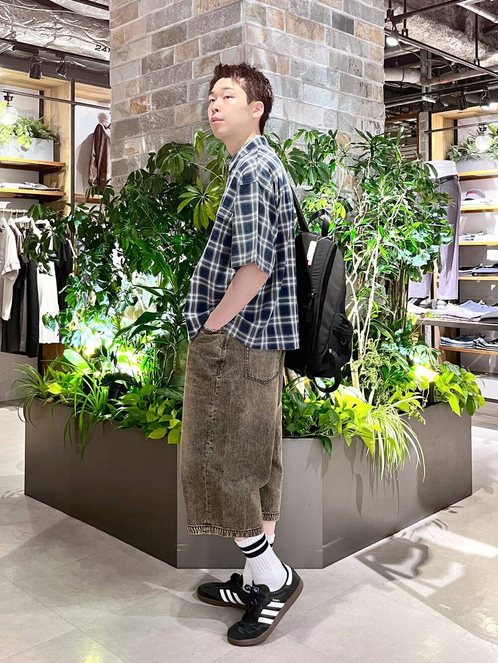 ブラック系のバックパック/リュック、ホワイト系のタンクトップ、グレー系のデニムパンツを着用したメンズの夏コーディネートの2枚目の写真