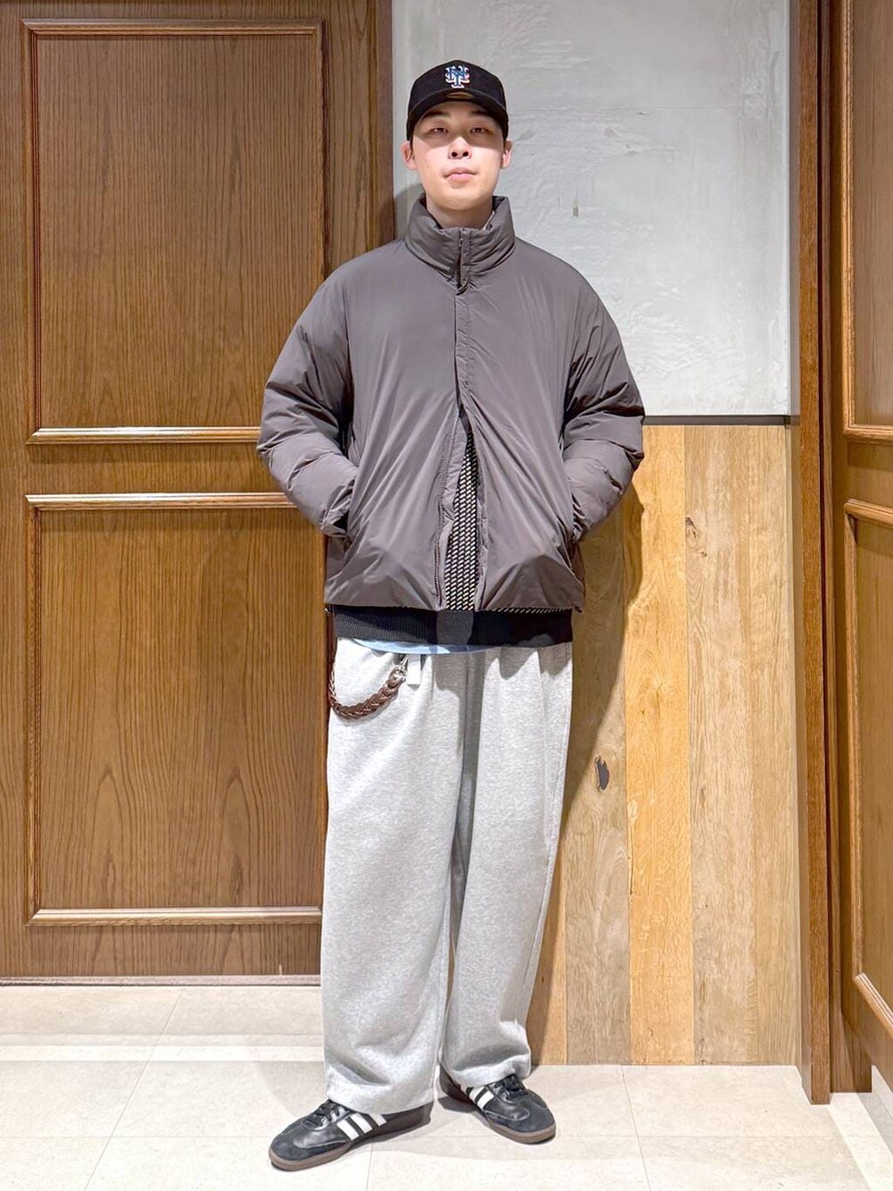 グレー系のダウンジャケット/コート、ブラック系のニット/セーター、グレー系のスウェットパンツを着用したメンズの秋コーディネートの4枚目の写真