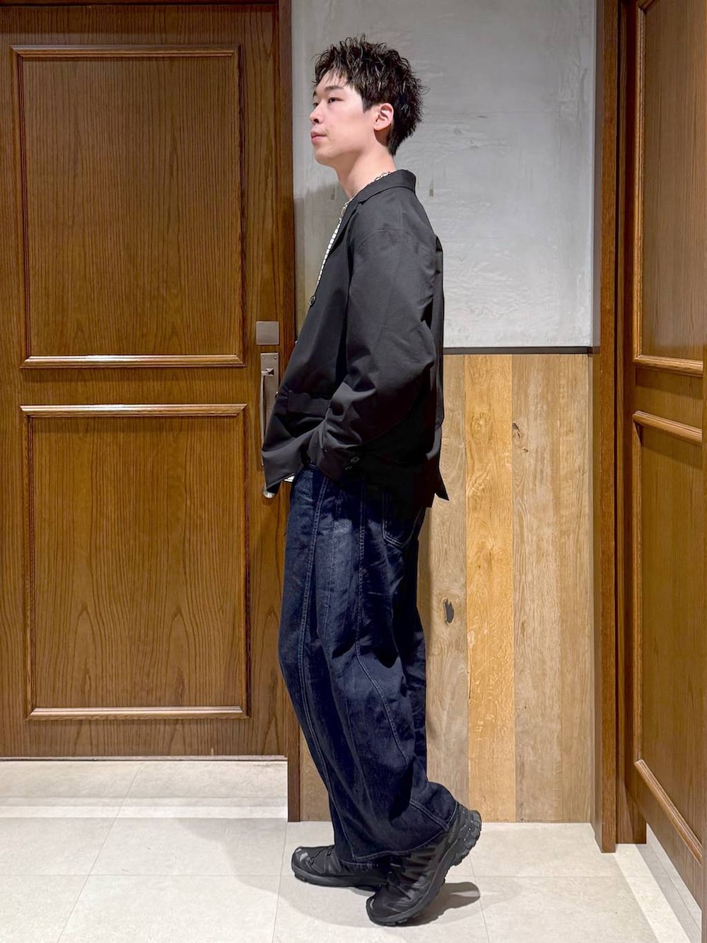 ブラック系のテーラードジャケット、ホワイト系のTシャツ/カットソー、ブルー系のデニムパンツを着用したメンズの春コーディネートの3枚目の写真