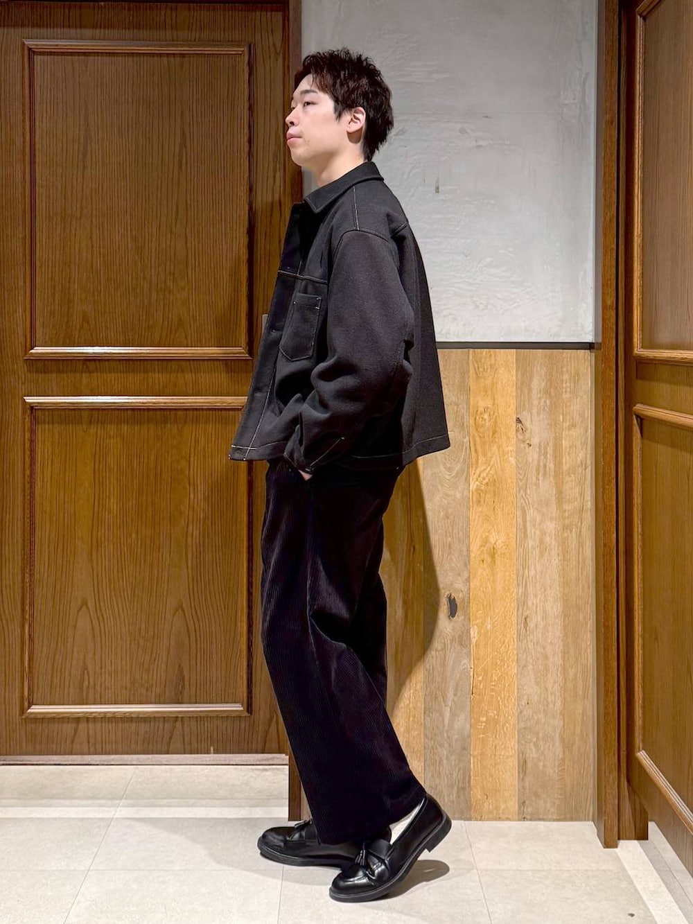 ブラック系のスラックス、ブラック系のブルゾン、ブラック系のカーディガン/ボレロを着用したメンズの秋コーディネートの4枚目の写真