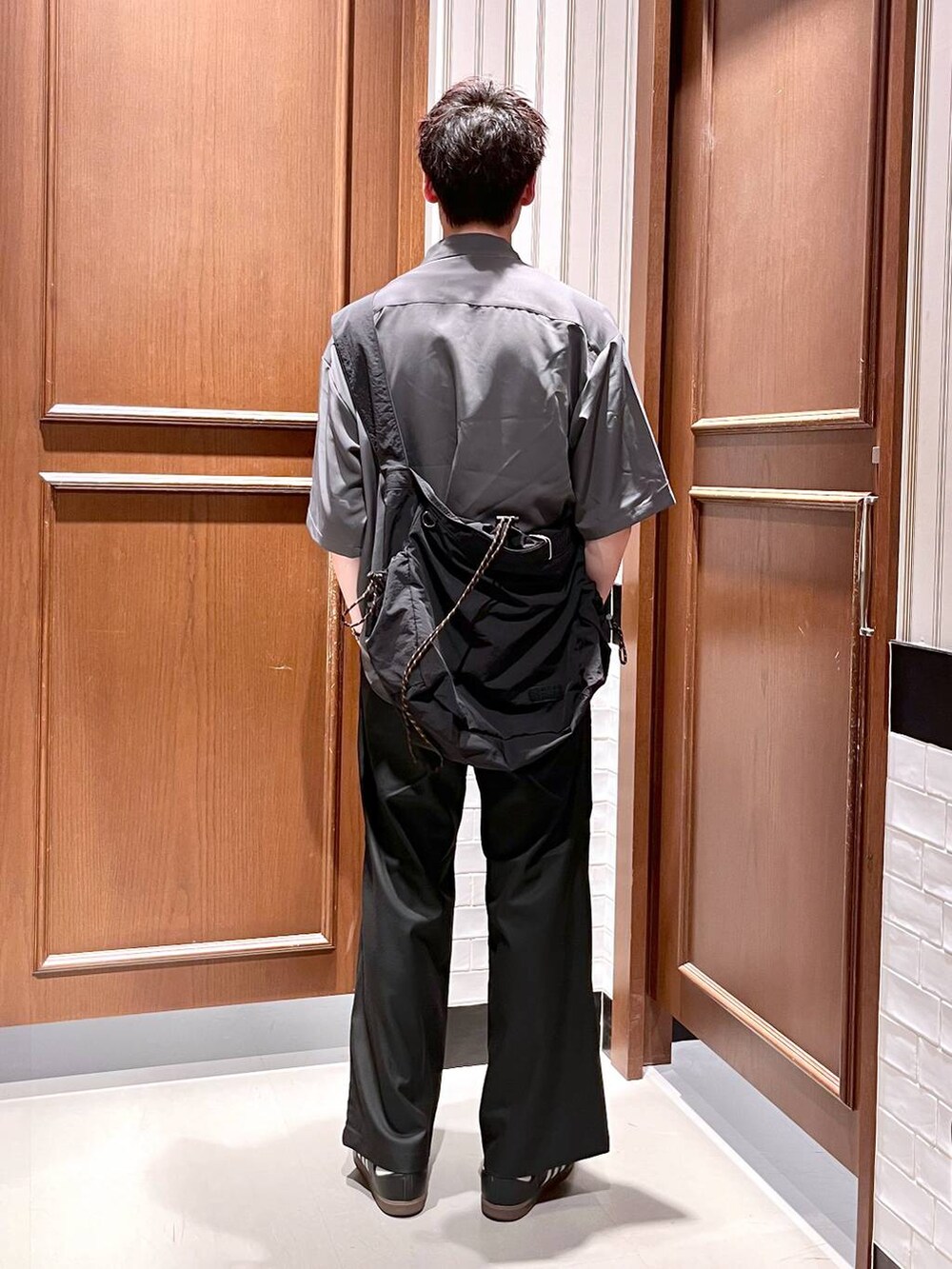 ブラック系のスラックス、グレー系のシャツ/ブラウス、ブラック系のショルダーバッグを着用したメンズの夏コーディネートの5枚目の写真