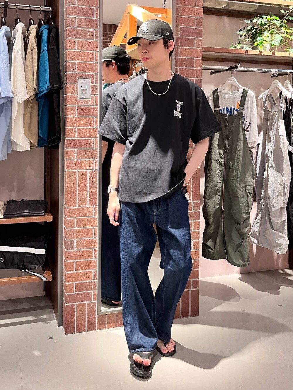 ブルー系のデニムパンツ、ブラック系のTシャツ/カットソー、パープル系のネックレスを着用したメンズの夏コーディネートの4枚目の写真