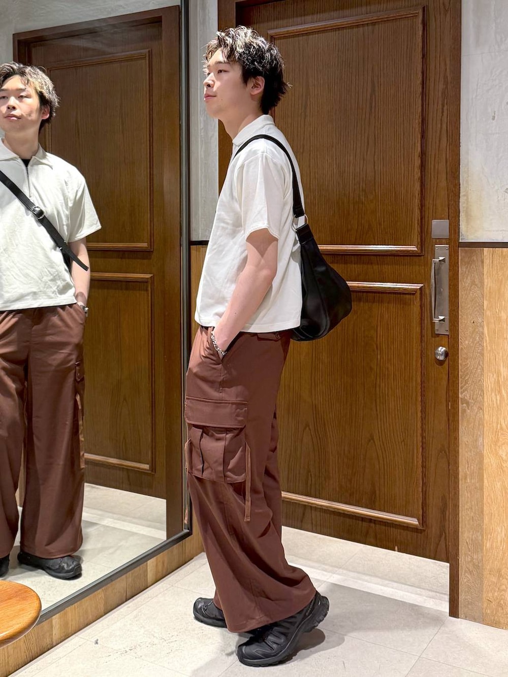 ブラック系のショルダーバッグ、イエロー系のスラックス、ホワイト系のTシャツ/カットソーを着用したメンズの春コーディネートの4枚目の写真