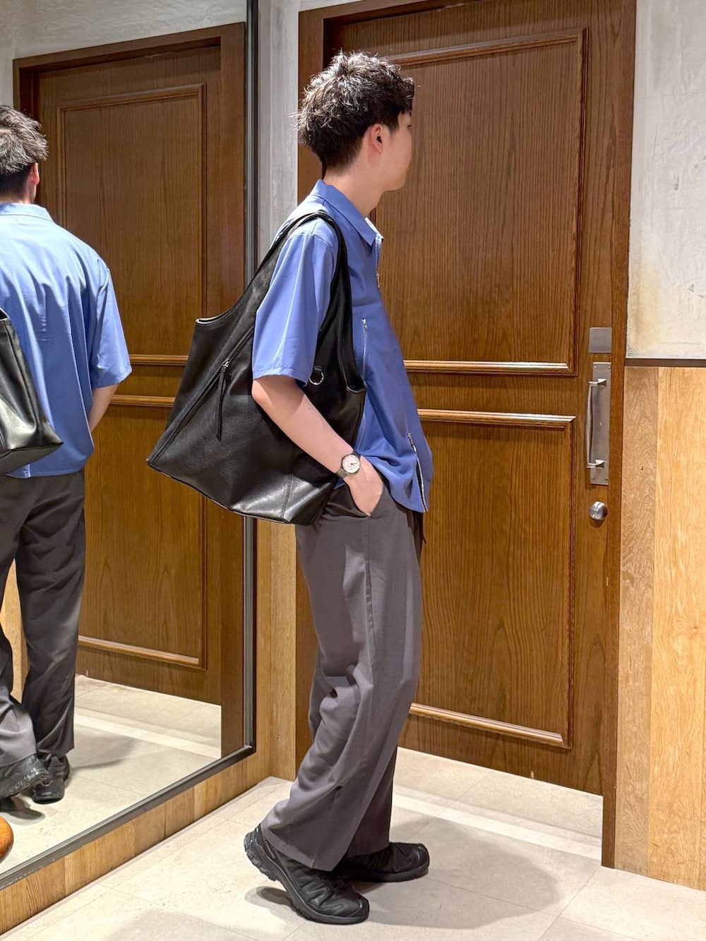 グレー系のスラックス、ブラック系のトートバッグ、ホワイト系のTシャツ/カットソーを着用したメンズの春コーディネートの4枚目の写真