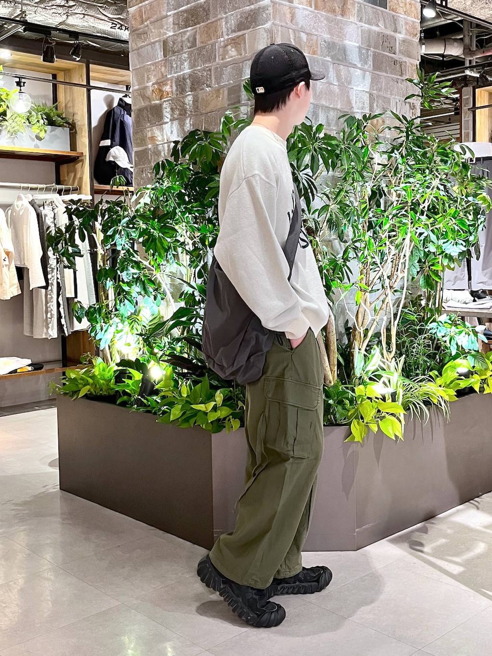 グリーン系のカーゴパンツ、その他のショルダーバッグ、ホワイト系のニット/セーターを着用したメンズの春コーディネートの3枚目の写真