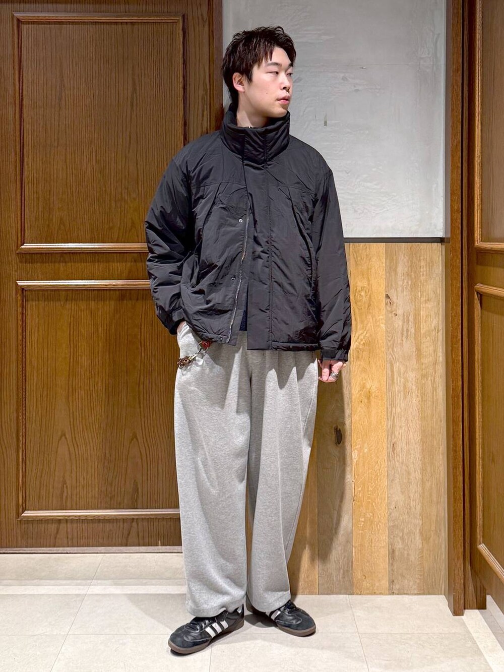 ブラック系のダウンジャケット/コート、ブルー系のニット/セーター、グレー系のスウェットパンツを着用したメンズの冬コーディネートの3枚目の写真