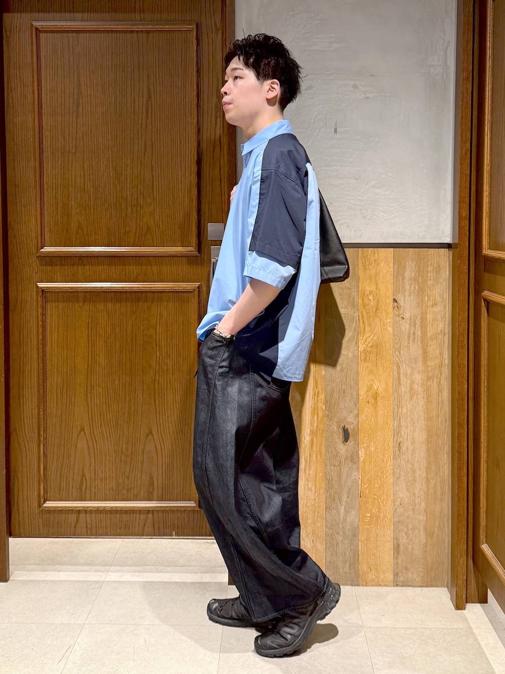 ブラック系のトートバッグ、ブルー系のデニムパンツ、ブルー系のシャツ/ブラウスを着用したメンズの春コーディネートの3枚目の写真