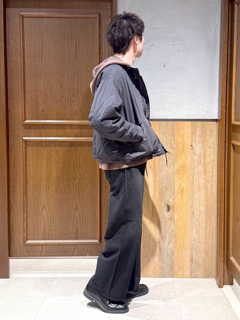 ブラック系のデニムパンツ、ブラック系のモッズコート、ブラウン系のニット/セーターを着用したメンズの冬コーディネートの6枚目の写真