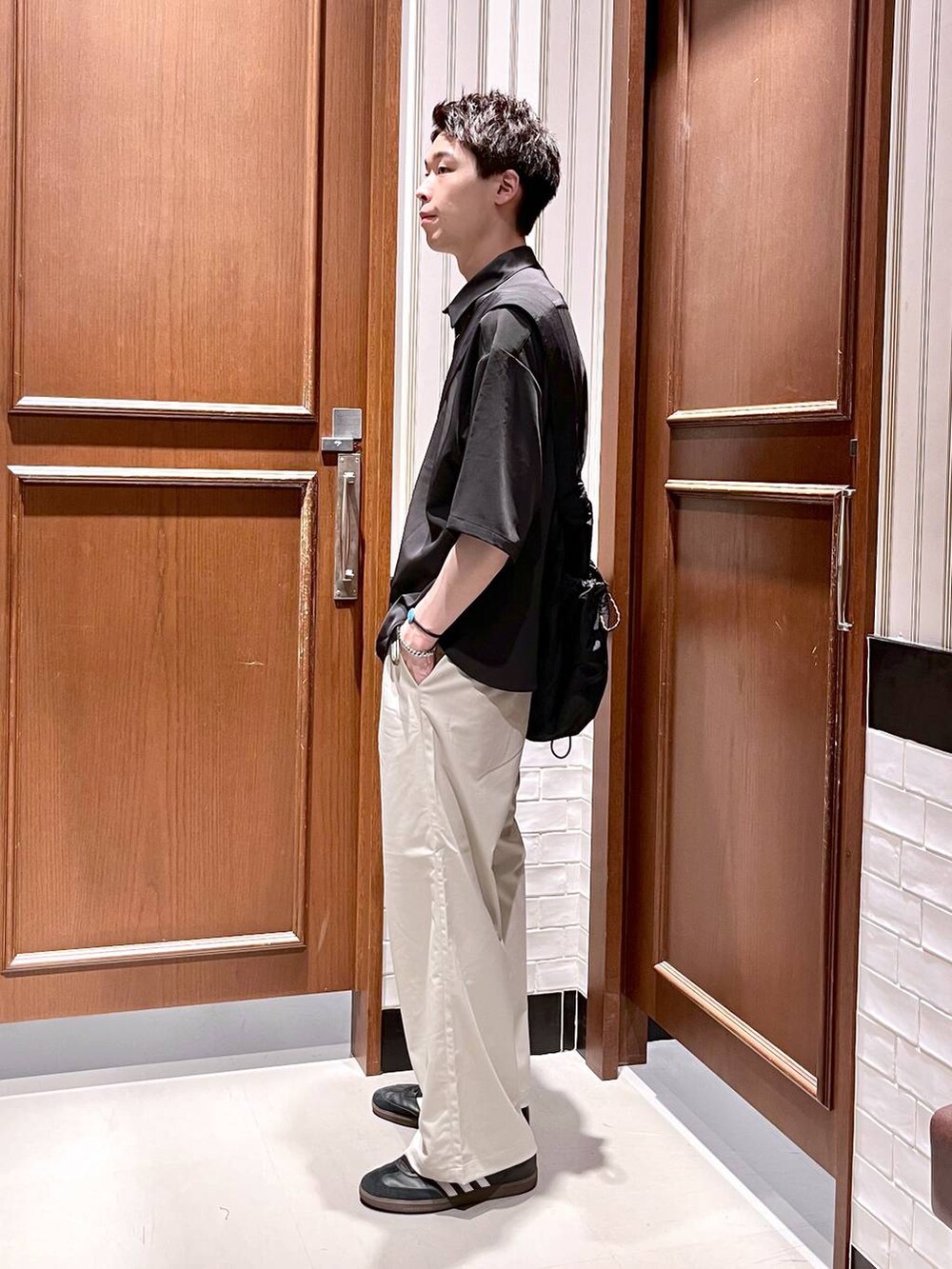 ホワイト系のスラックス、ブラック系のシャツ/ブラウス、ブラック系のショルダーバッグを着用したメンズの夏コーディネートの3枚目の写真