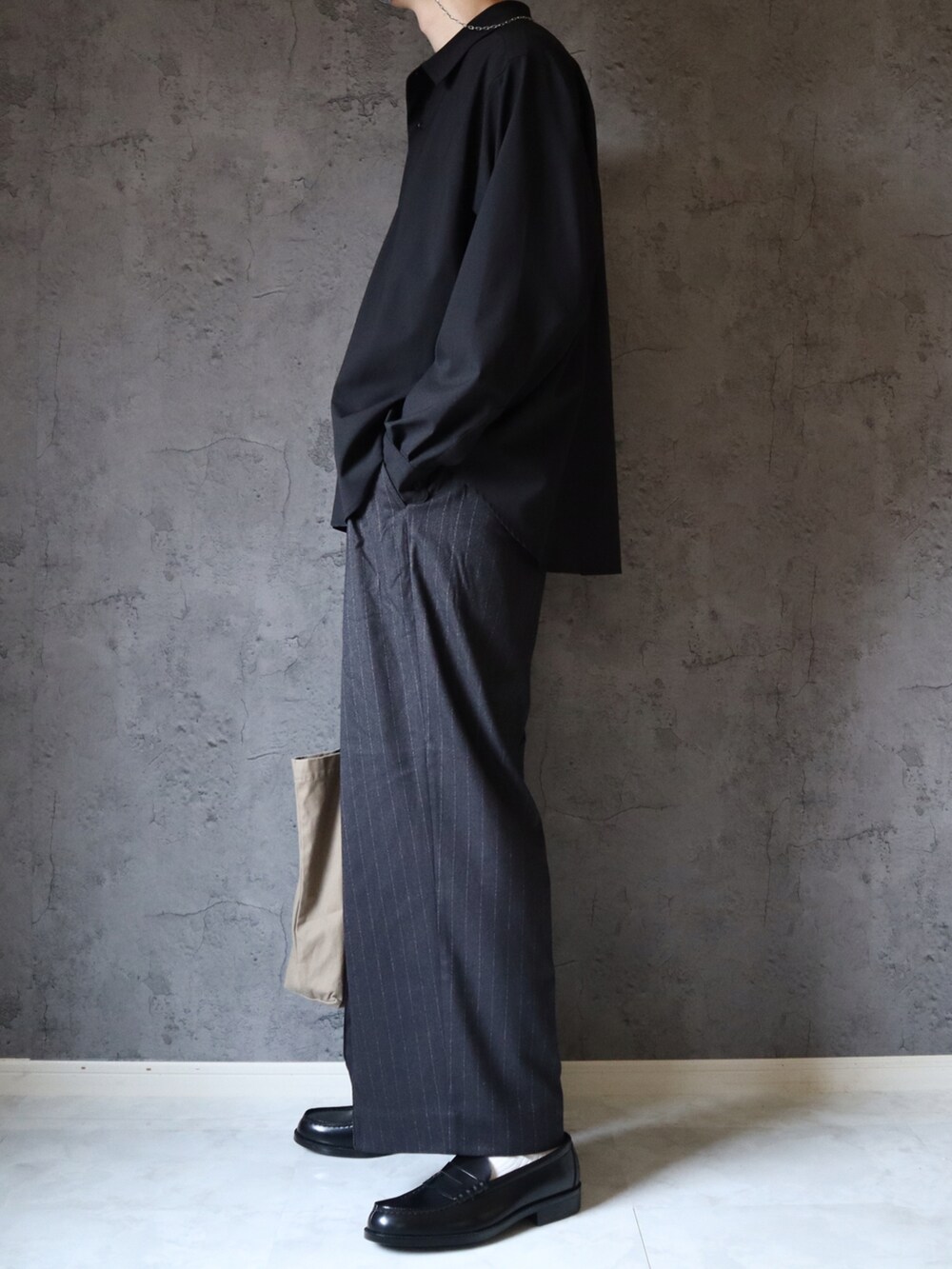 ブラック系のシャツ/ブラウス、ブラック系のスラックス、ブラック系のローファーを着用したメンズの夏コーディネートの3枚目の写真