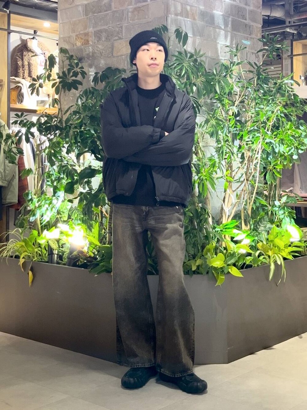 ブラック系のダウンジャケット/コート、グレー系のデニムパンツ、ブラック系のニット/セーターを着用したメンズの冬コーディネートの5枚目の写真