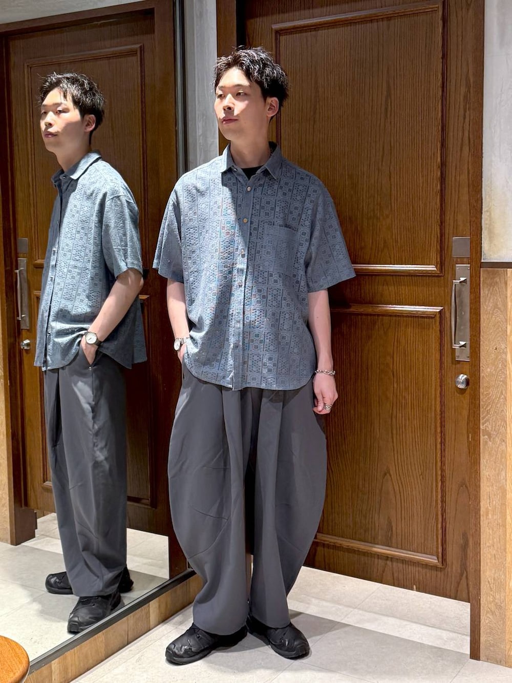 ブルー系のシャツ/ブラウス、グレー系のスラックス、ブラック系のTシャツ/カットソーを着用したメンズの夏コーディネートの3枚目の写真