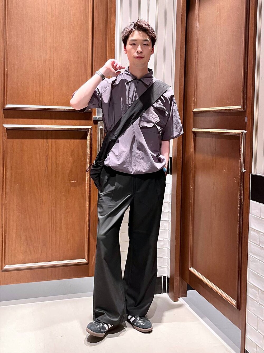 ブラック系のスラックス、ブラック系のショルダーバッグを着用したメンズの夏コーディネートの2枚目の写真