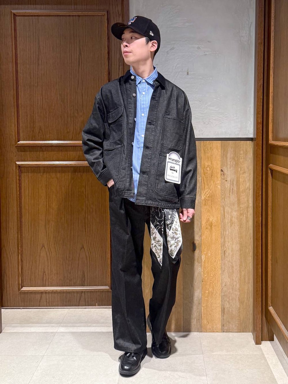 ブラック系のブルゾン、ブラック系のスラックス、ブラック系のバンダナ/スカーフを着用したメンズの冬コーディネートの7枚目の写真