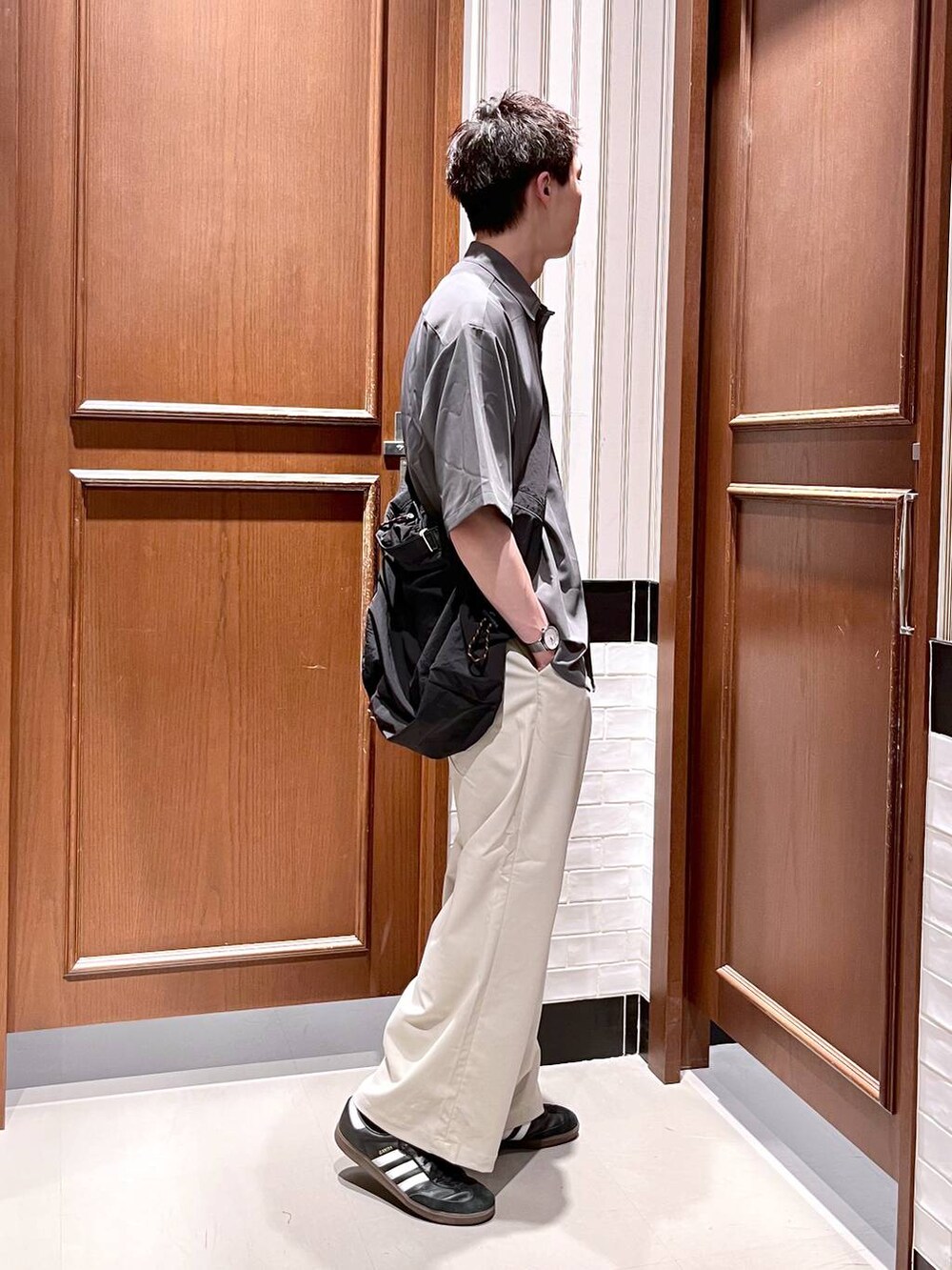 ホワイト系のスラックス、グレー系のシャツ/ブラウス、ブラック系のショルダーバッグを着用したメンズの夏コーディネートの3枚目の写真
