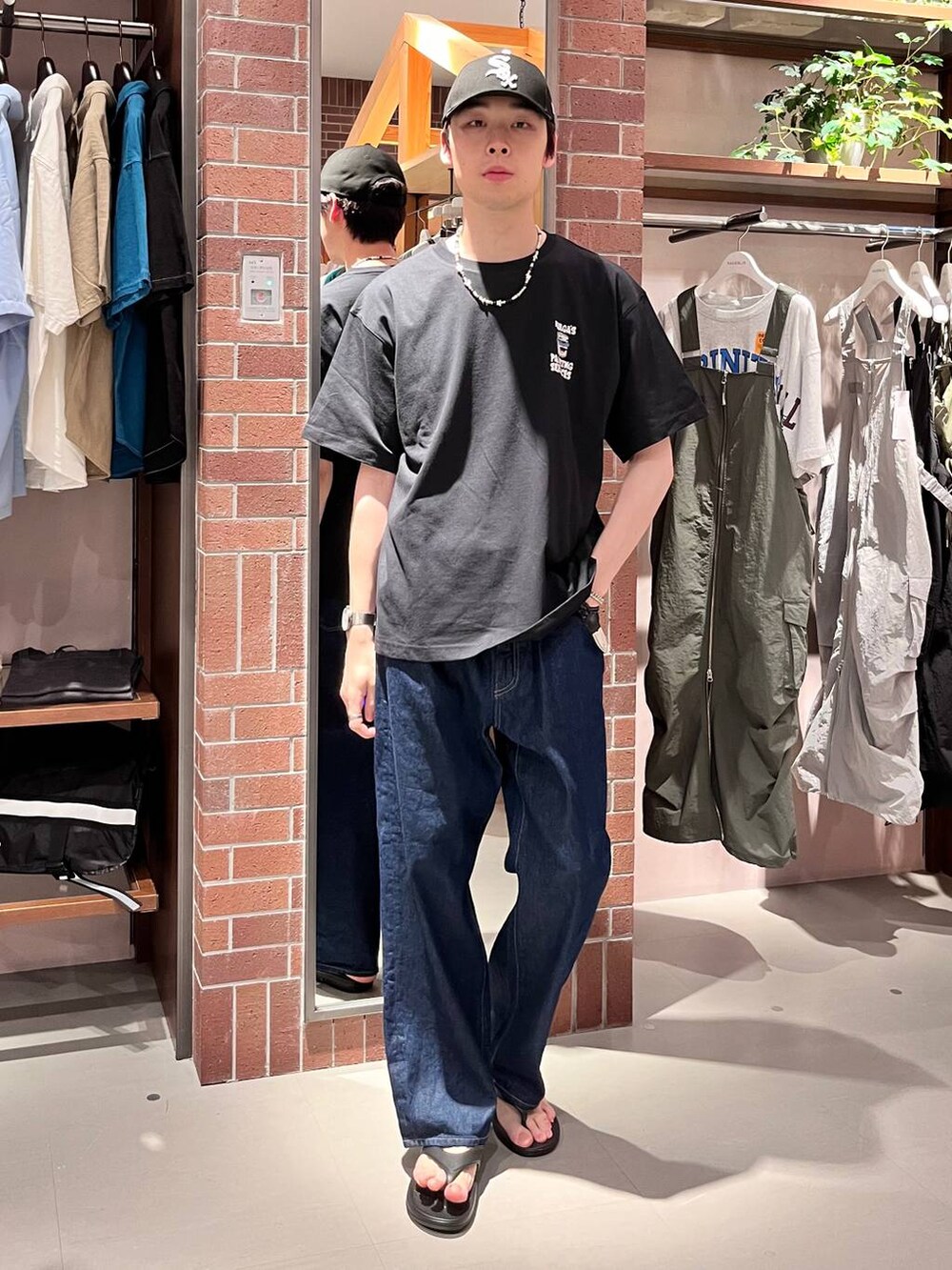 ブルー系のデニムパンツ、ブラック系のTシャツ/カットソー、パープル系のネックレスを着用したメンズの夏コーディネートの6枚目の写真