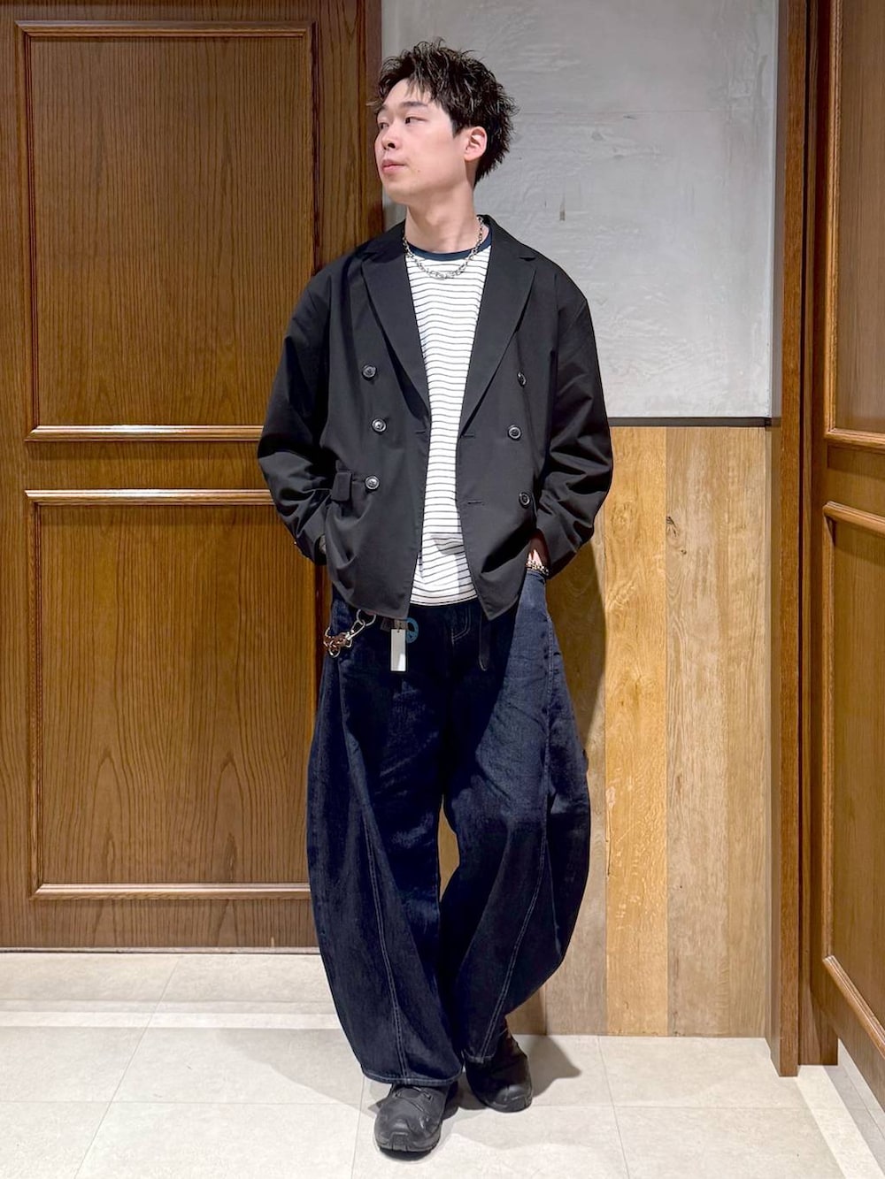 ブラック系のテーラードジャケット、ホワイト系のTシャツ/カットソー、ブルー系のデニムパンツを着用したメンズの春コーディネートの6枚目の写真