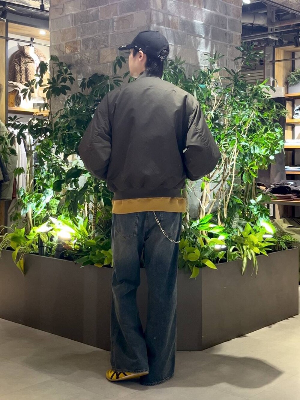 ブルー系のデニムパンツ、グリーン系のMA-1、イエロー系のスウェットを着用したメンズの秋コーディネートの4枚目の写真