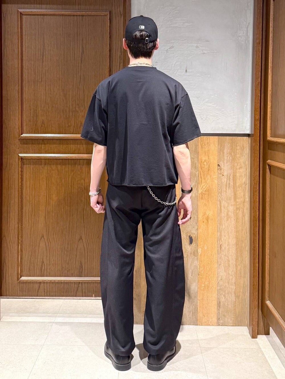 ブラック系のスラックス、ブラック系のTシャツ/カットソー、シルバー系のウォレットチェーンを着用したメンズの春コーディネートの5枚目の写真