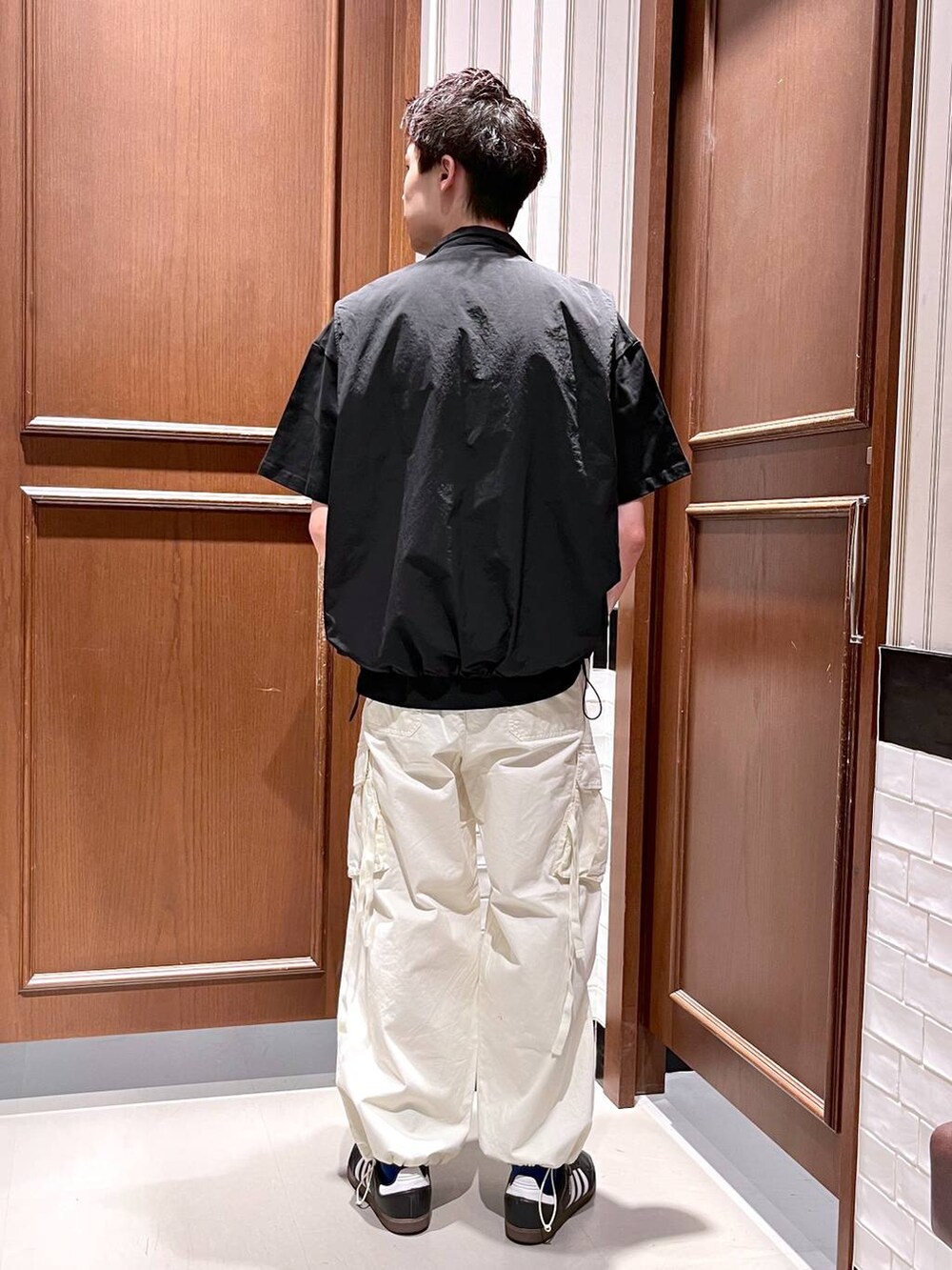 ホワイト系のカーゴパンツ、ブラック系のベスト、ブラック系のTシャツ/カットソーを着用したメンズの夏コーディネートの5枚目の写真