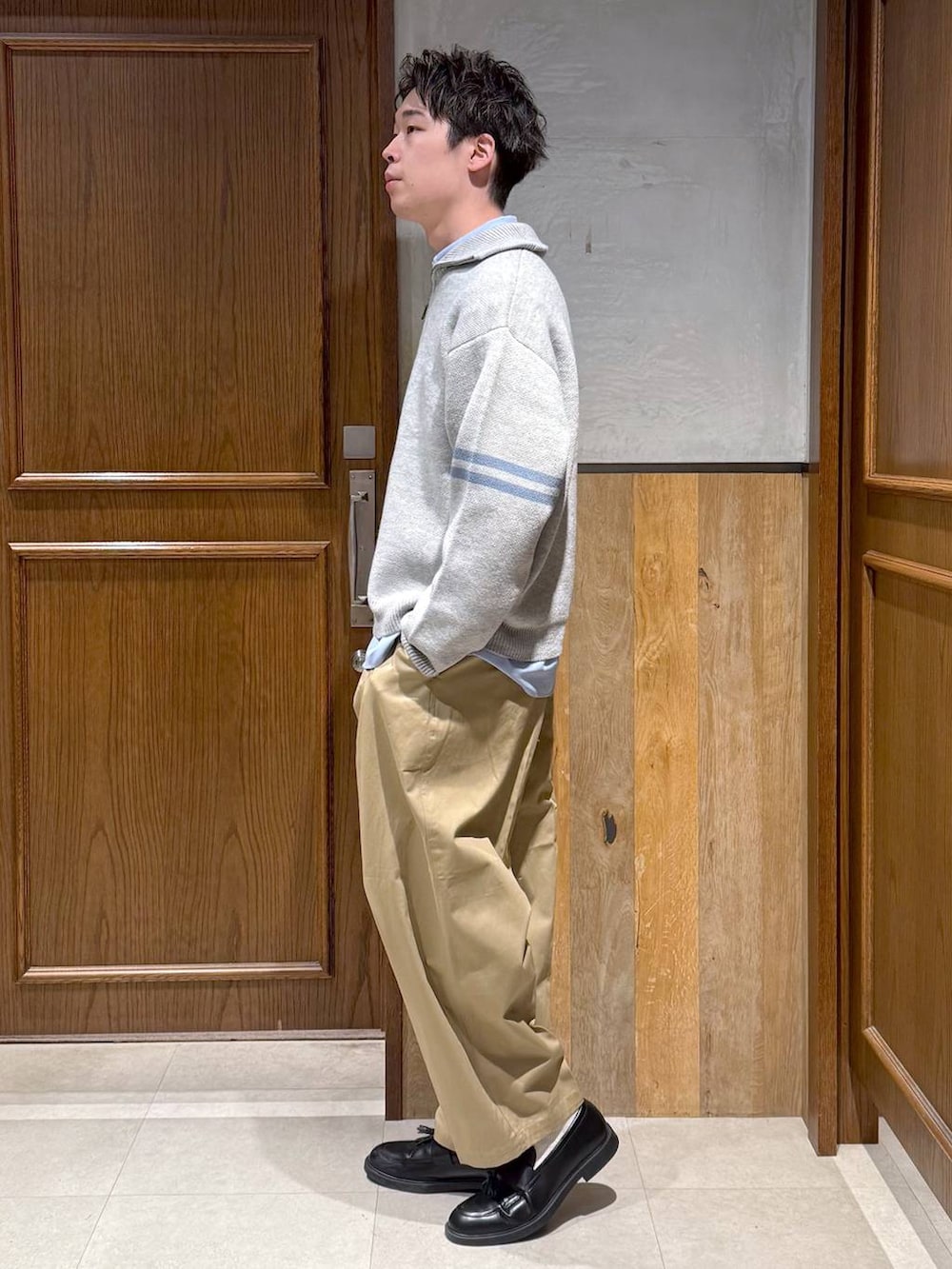 ブルー系のシャツ/ブラウス、ベージュ系のチノパンツ、グレー系のニット/セーターを着用したメンズの冬コーディネートの3枚目の写真