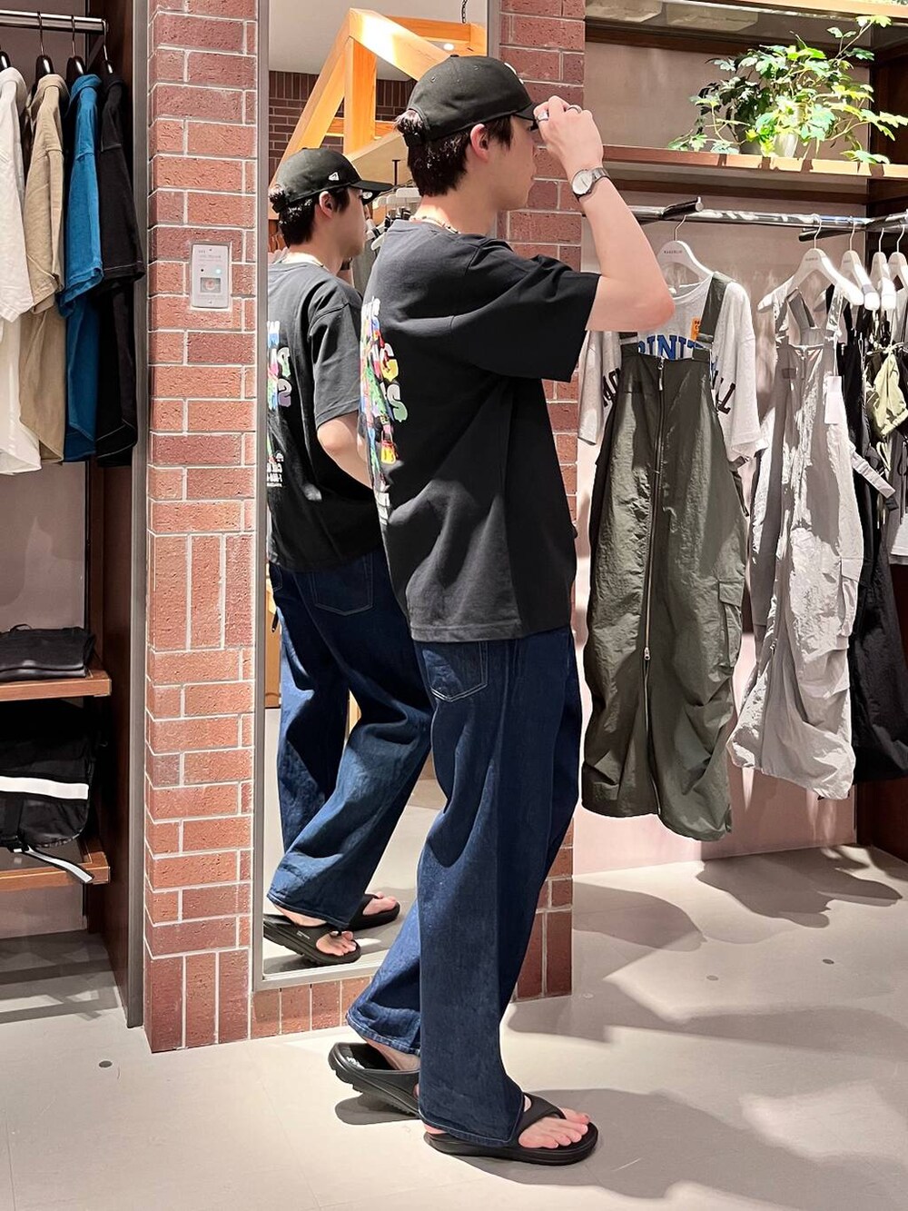 ブルー系のデニムパンツ、ブラック系のTシャツ/カットソー、パープル系のネックレスを着用したメンズの夏コーディネートの5枚目の写真