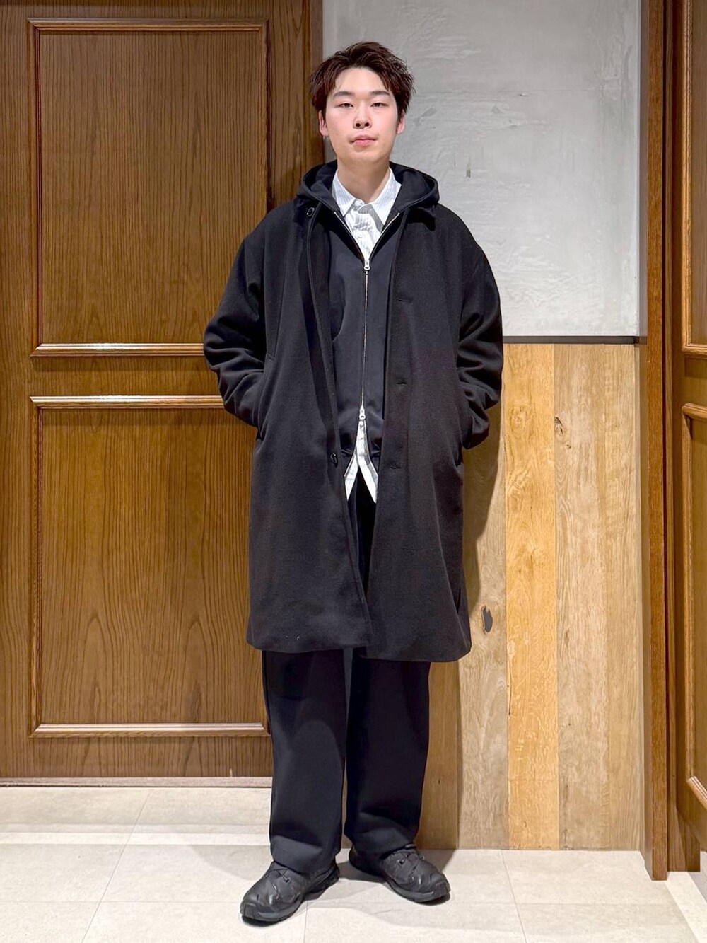 ブラック系のトレンチコート、ブルー系のシャツ/ブラウス、ブラック系のパーカーを着用したメンズの秋コーディネートの7枚目の写真