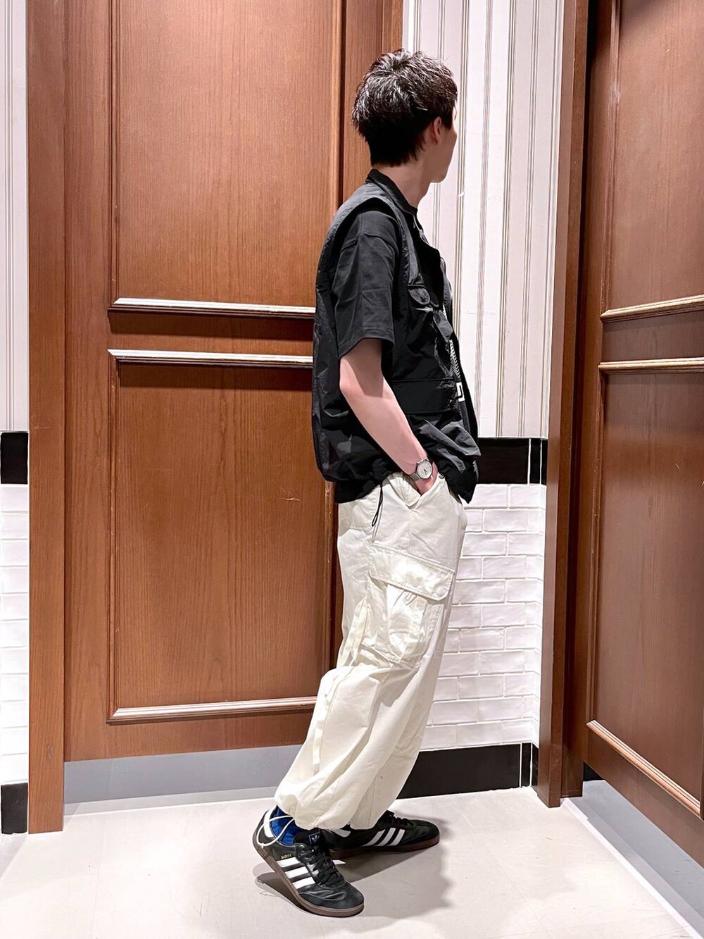 ホワイト系のカーゴパンツ、ブラック系のベスト、ブラック系のTシャツ/カットソーを着用したメンズの夏コーディネートの6枚目の写真