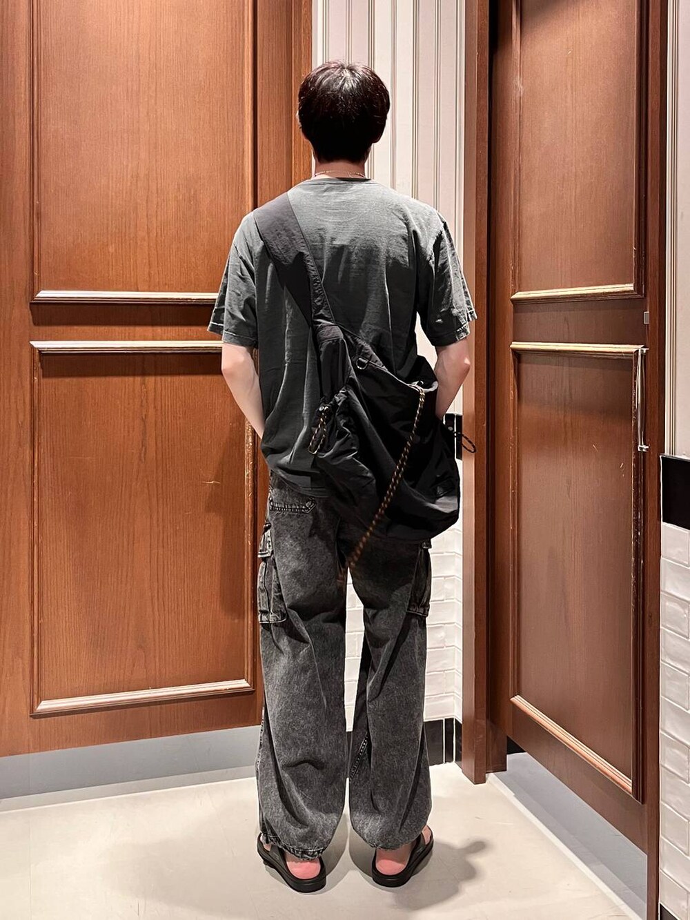 ブラック系のサンダル、グレー系のデニムパンツ、ブラック系のショルダーバッグを着用したメンズの夏コーディネートの4枚目の写真