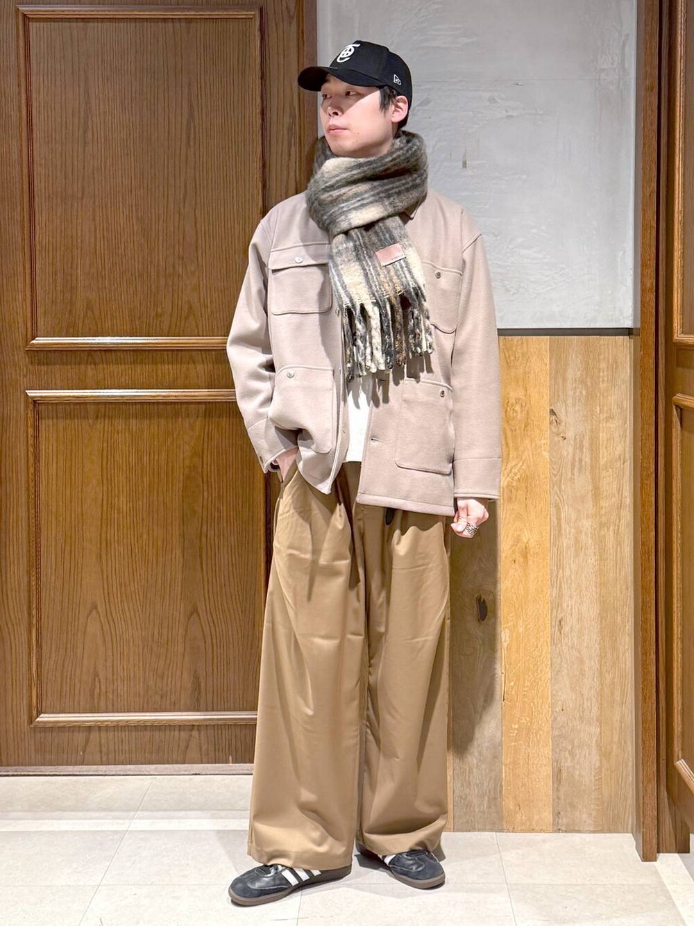 ホワイト系のニット/セーター、ベージュ系のブルゾン、ベージュ系のスラックスを着用したメンズの冬コーディネートの2枚目の写真