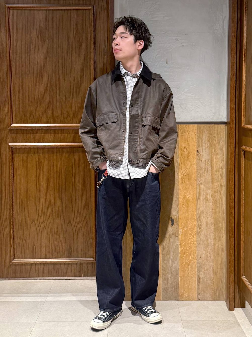 ブラウン系のブルゾン、ブルー系のデニムパンツ、ホワイト系のシャツ/ブラウスを着用したメンズの冬コーディネートの2枚目の写真